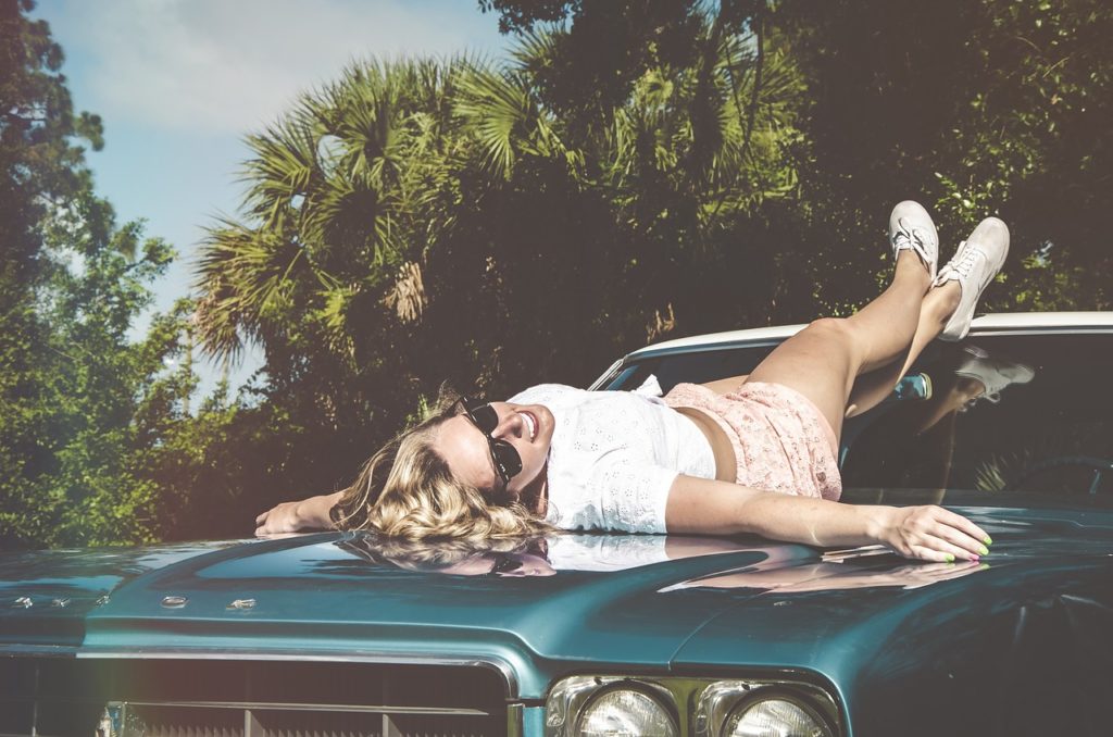 image of a woman relaxing under the sun on a car