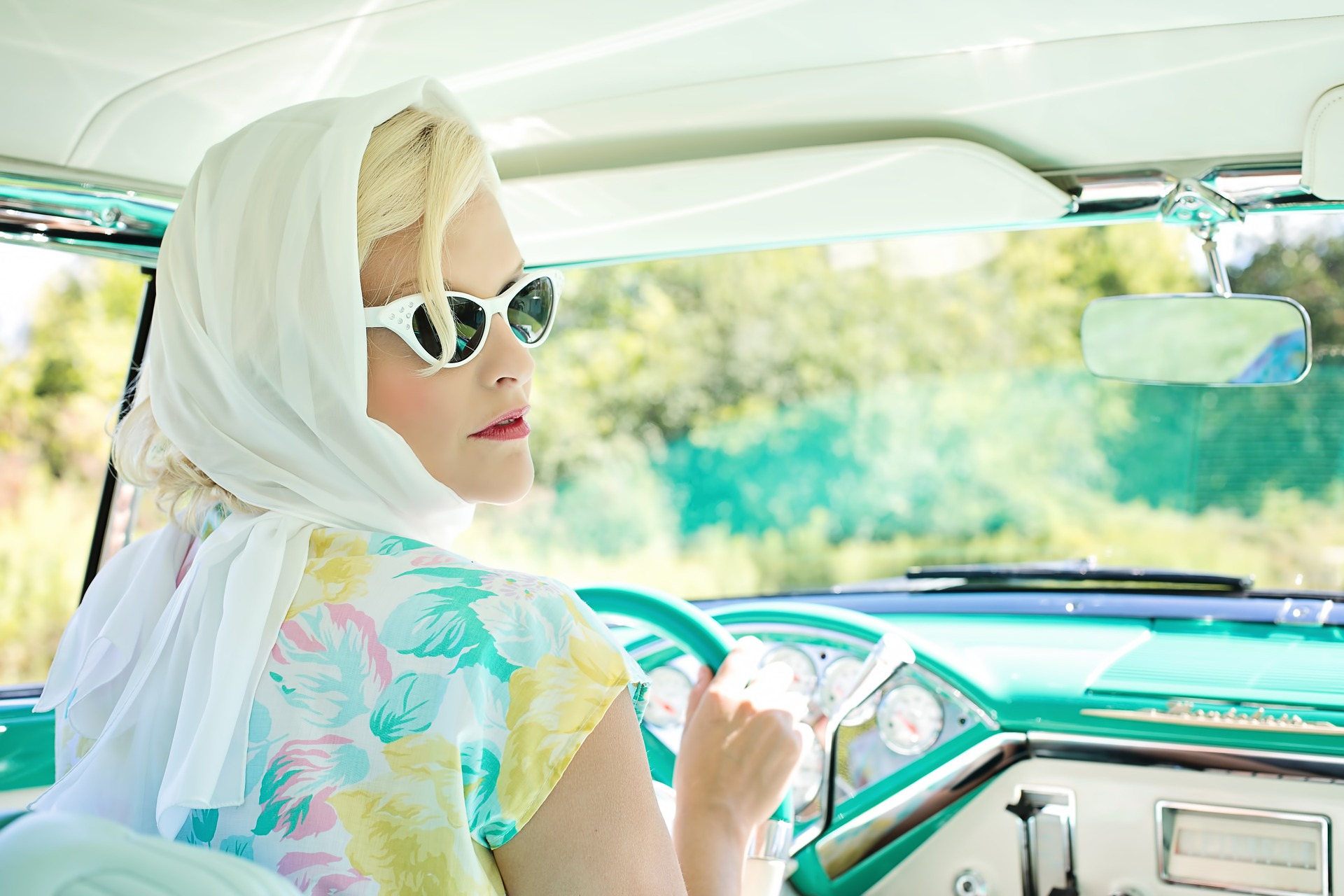 a woman driving a vintage car